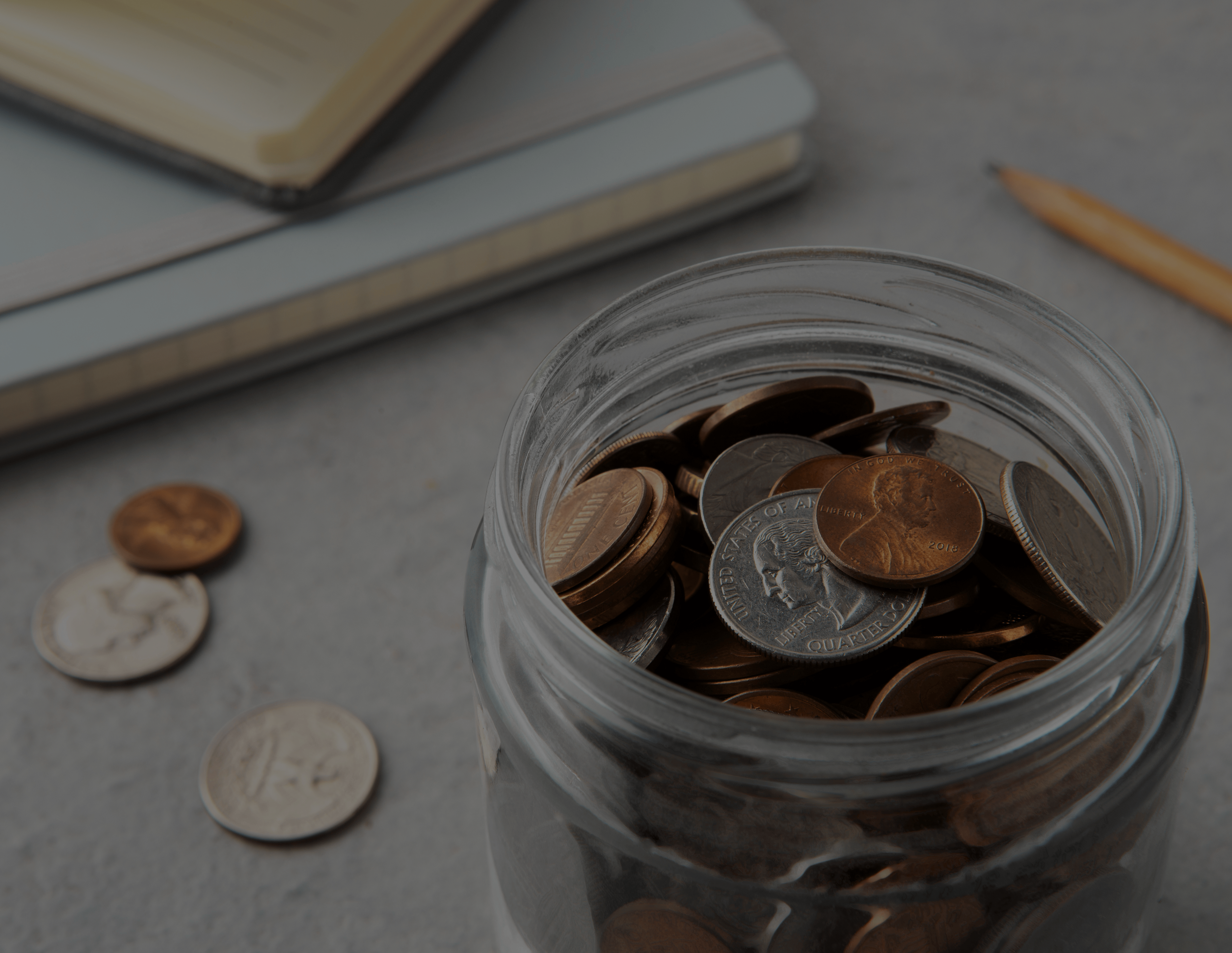 Jarra de vidrio llena de monedas representando ahorros y giros